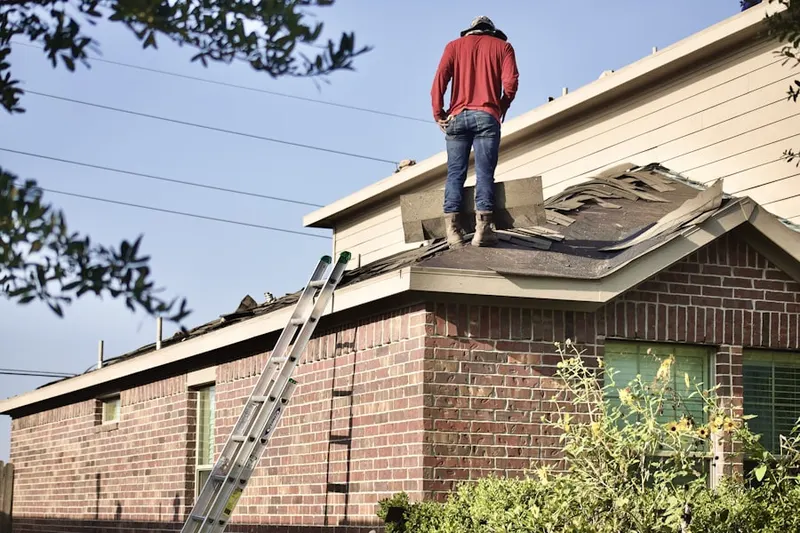 Professional roofer working on a residential roof in Astor